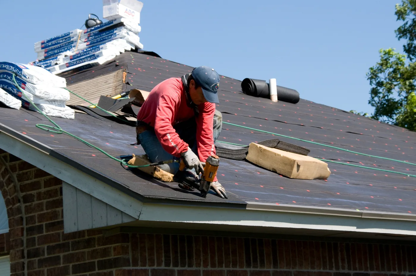 Roofing professional installing a new asphalt shingle roof